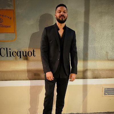 Jake is wearing completely black. He is wearing black suit, black shirt, black pant.